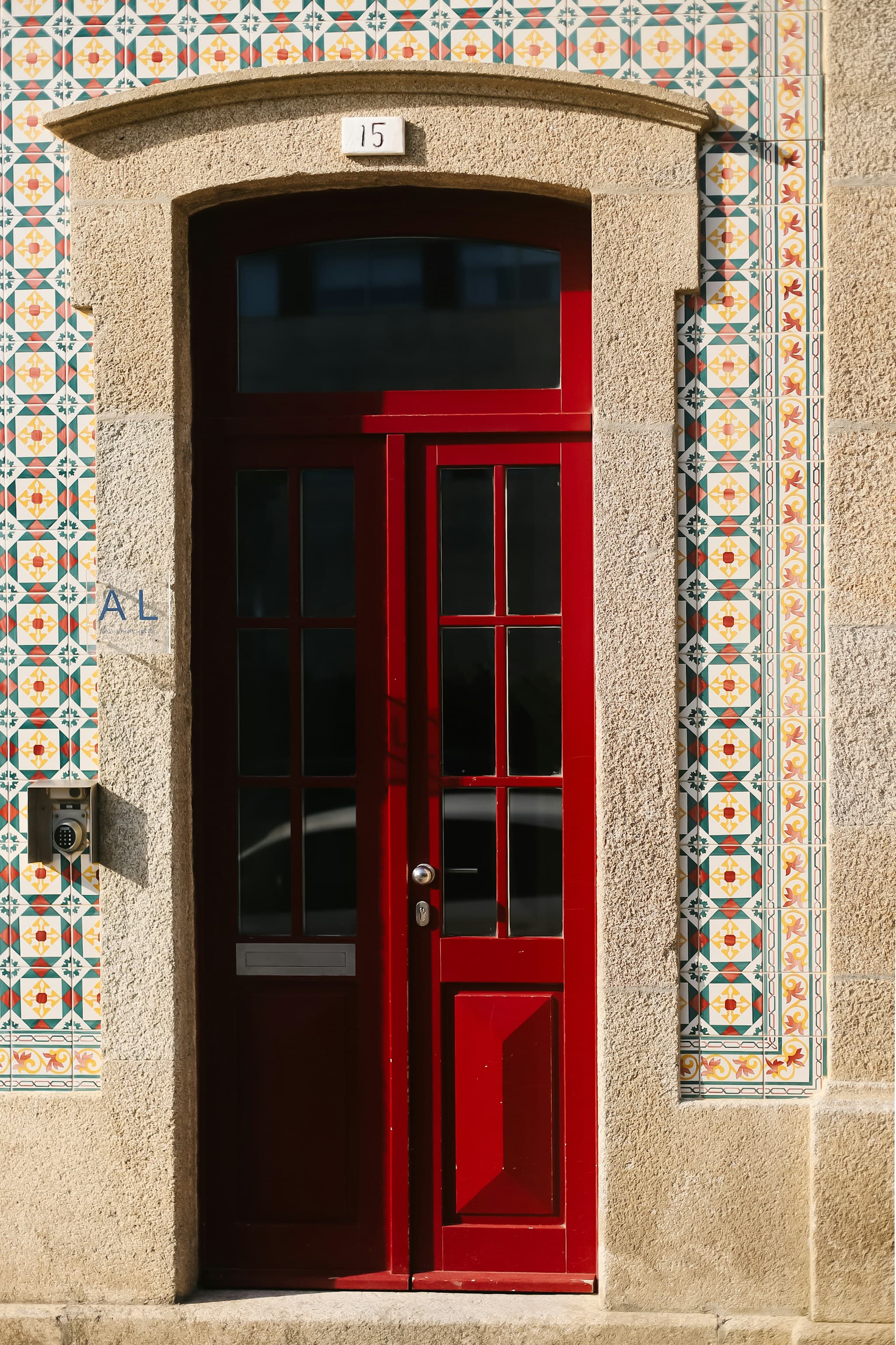 A red doorway framed by traditional azulejo tiles in Portugal